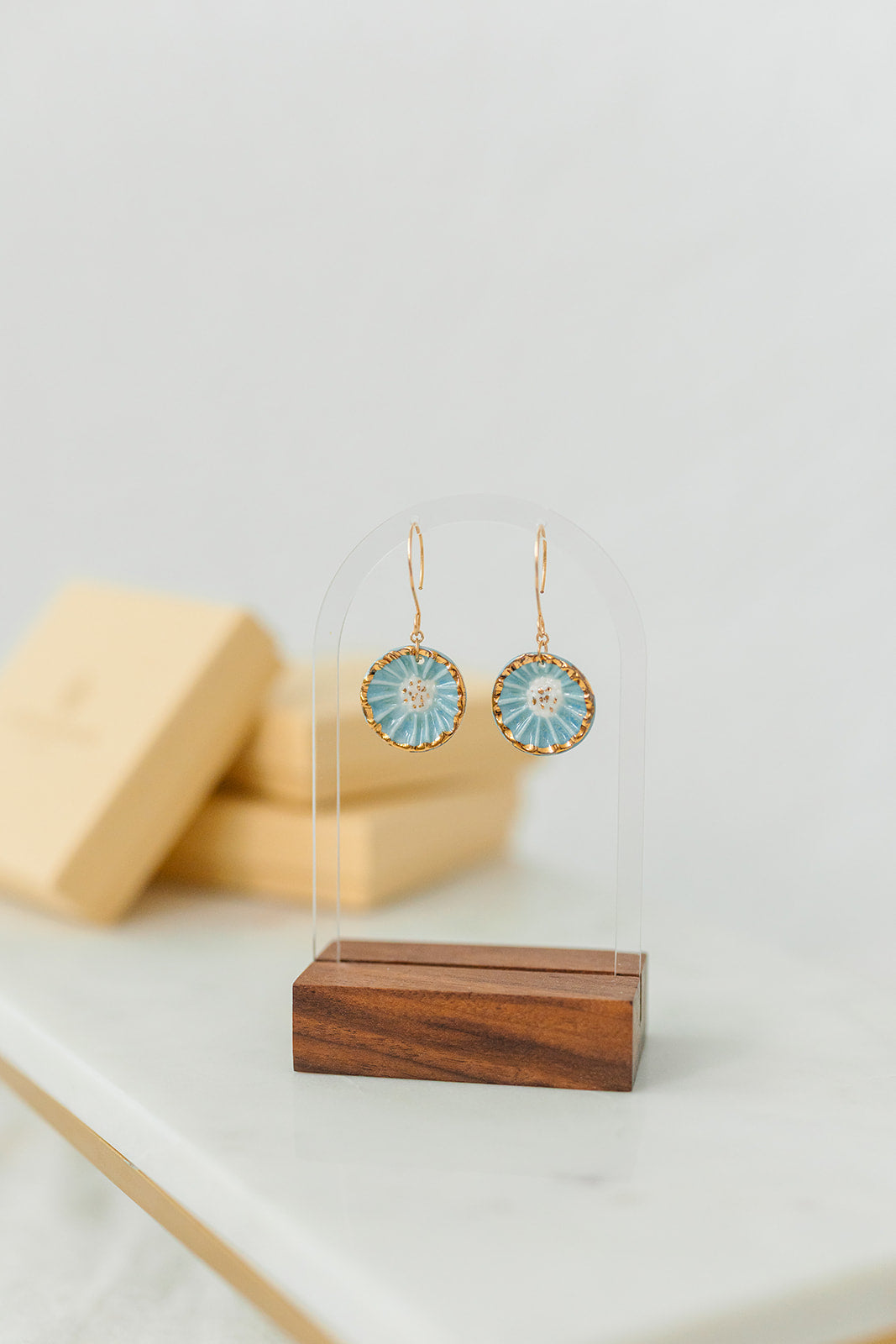 Handcrafted porcelain Anemone earrings with a blue glaze, sculptural radial texture, and hand-applied 22k gold accents.