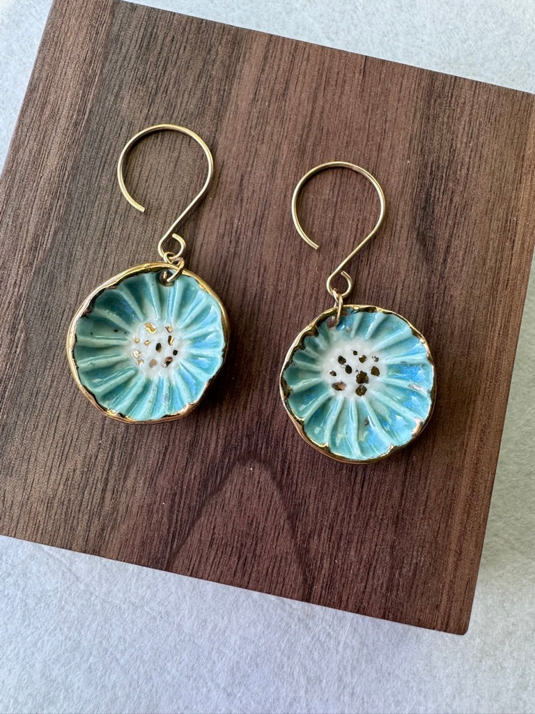 Handcrafted porcelain Anemone earrings with a blue glaze, sculptural radial texture, and hand-applied 22k gold accents.