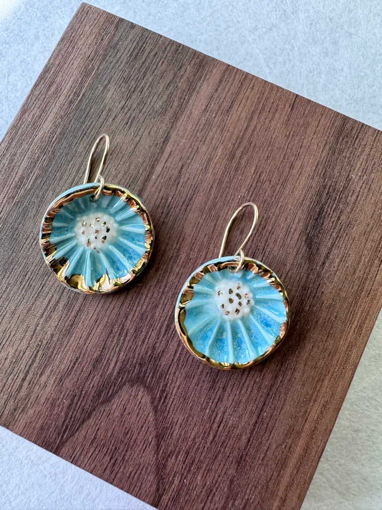 Handcrafted porcelain Anemone earrings with a blue glaze, sculptural radial texture, and hand-applied 22k gold accents.