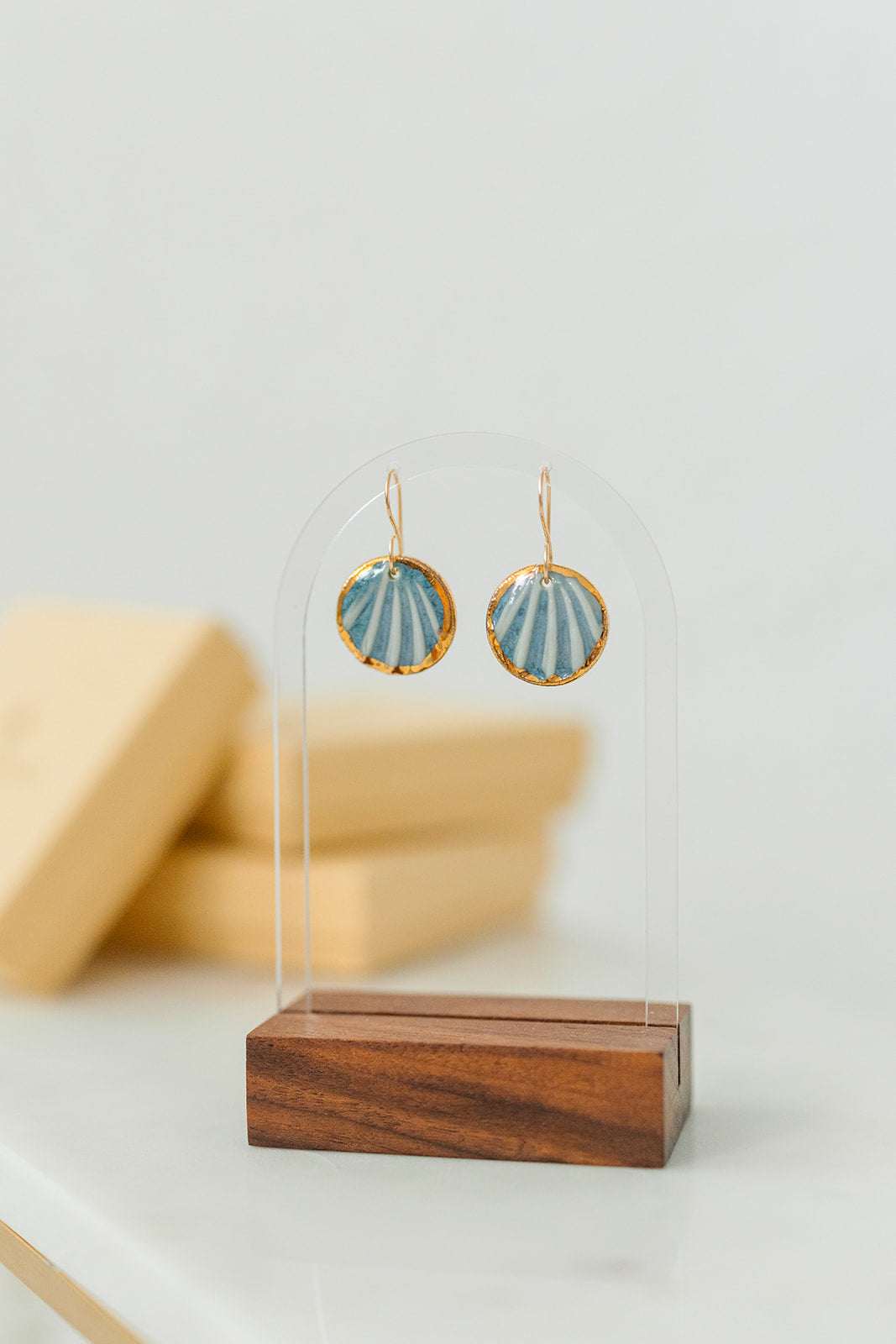 Handcrafted blue porcelain Maris earrings with shell-inspired texture and hand-applied 22k gold accents.