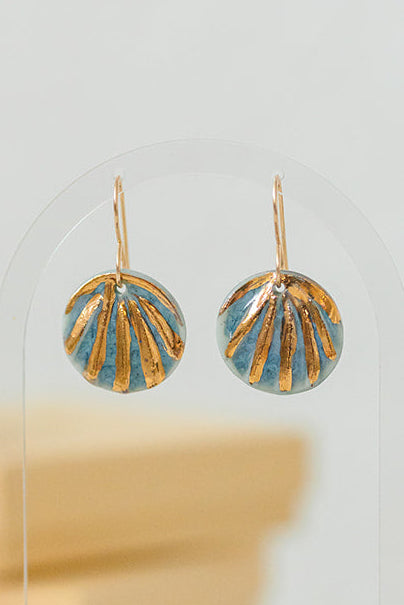 Blue handcrafted porcelain Maris earrings featuring shell-inspired relief and hand-applied 22k gold details.
