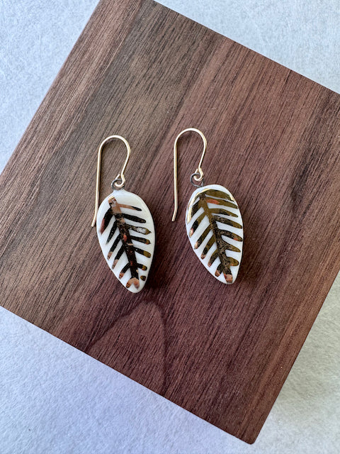 White porcelain leaf earrings featuring hand-applied 22k gold botanical details and gold-filled ear wires.