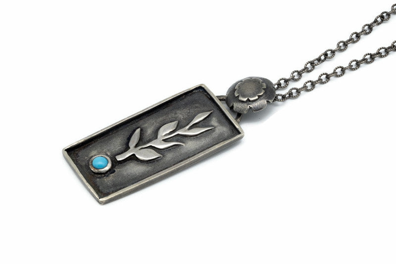 Handcrafted sterling silver necklace with a botanical branch design and Sleeping Beauty turquoise stone.
