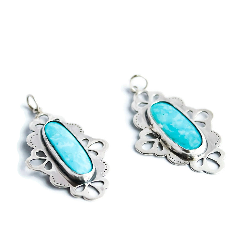 Handcrafted sterling silver pendant with a natural turquoise stone and lace-inspired openwork details.